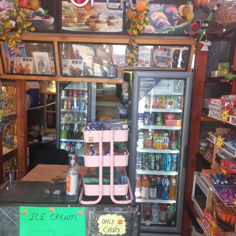 Interior del local con mostrador y refrigeradores de bebidas